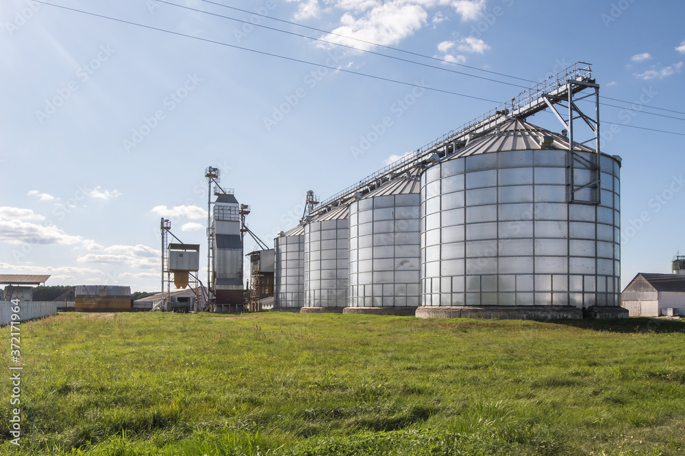Modern Granary elevator. Silver silos on agro-processing and manufacturing plant for processing drying cleaning and storage of agricultural products, flour, cereals and grain. Modern Granary elevator. Silver silos on agro-processing and manufacturing plant for processing drying cleaning and storage of agricultural products, flour, cereals and grain.