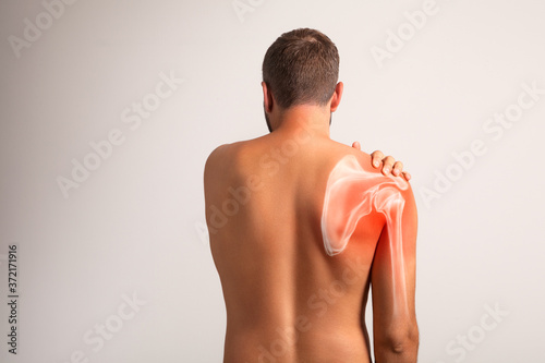 Shoulder pain, man holding a hand on a painful zone