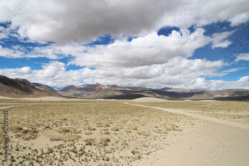 View of the mountain and sand dune with dirt road near Tingri on the way to Everest Base Camp, Tibet, China