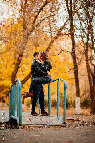 man and woman on bridge over stream in autumn Park