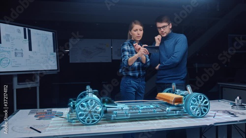 Automotive Engineer Wearing Virtual Reality Headset Working on 3D Electric Car Design, Using Gestures in Augmented Reality.  Designing Graphical Parts, Picks Body and Color for the Chassis, Engine photo