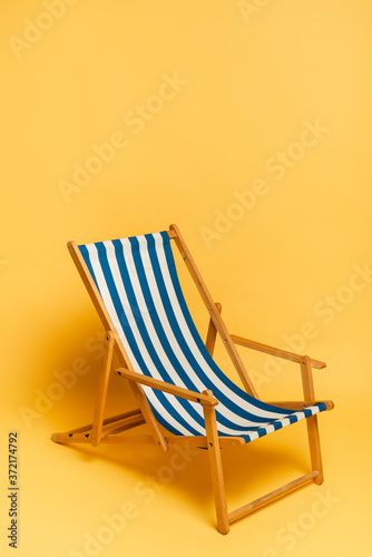 Canvas Print blue and white deckchair on yellow with copy space