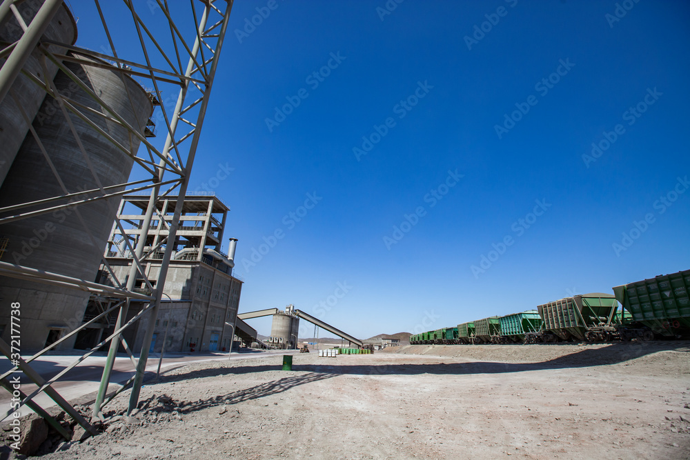 Mynaral/Kazakhstan: Modern Jambyl Cement plant in desert. Hopper cars on railroad filling and loading terminal.