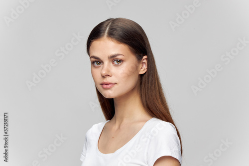 Woman portrait on a light background in a t-shirt beautiful face brunette Copy space