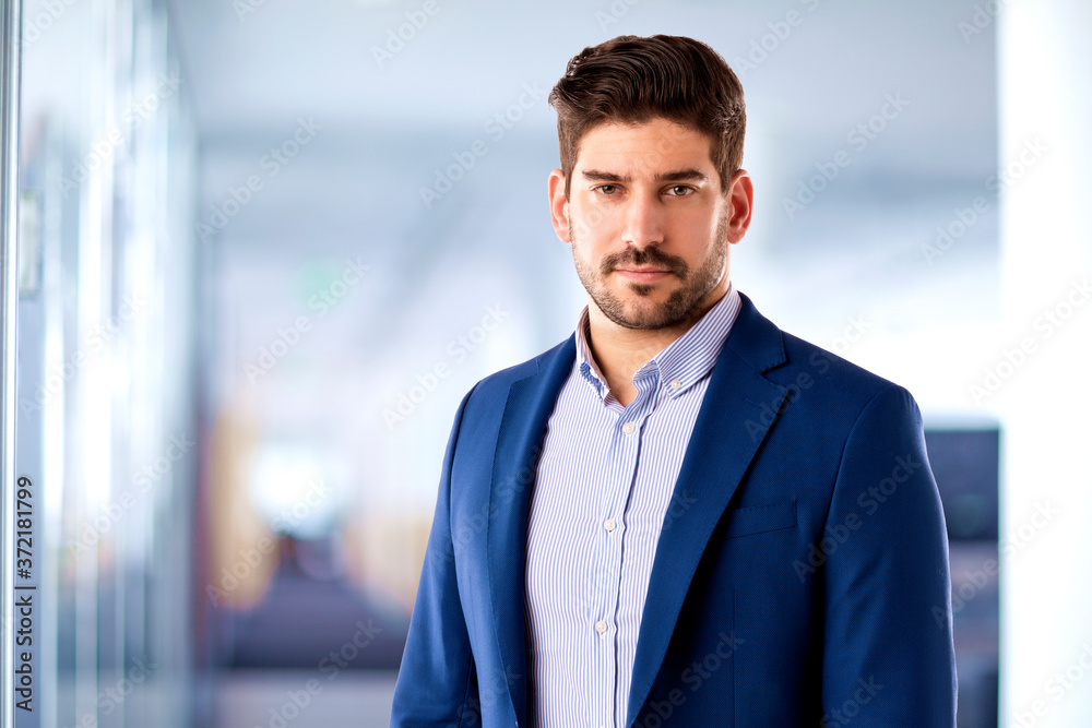 Confident businessman portrait while standing in the office Confident businessman portrait while standing in the office