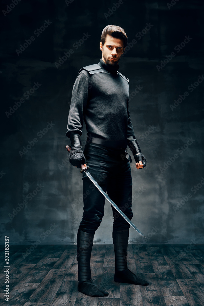 Full length portrait of warrior man posing with a sword Full length portrait of warrior man posing with a sword