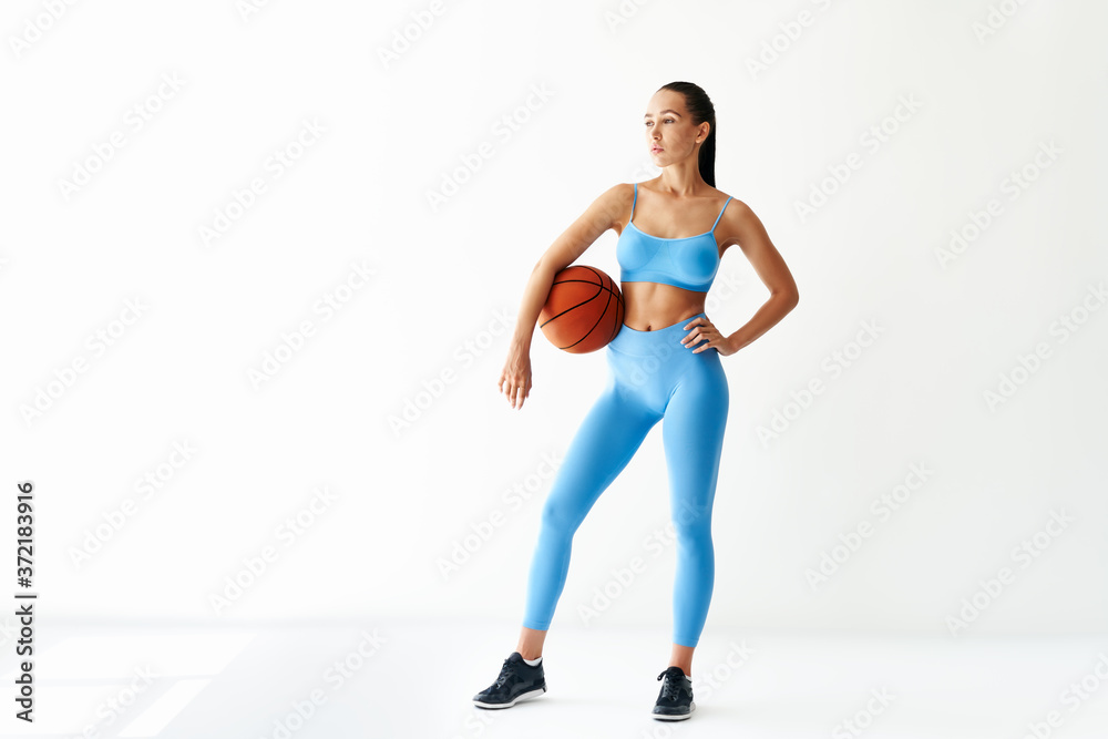 Full length portrait of beautiful sexy girl with a basketball