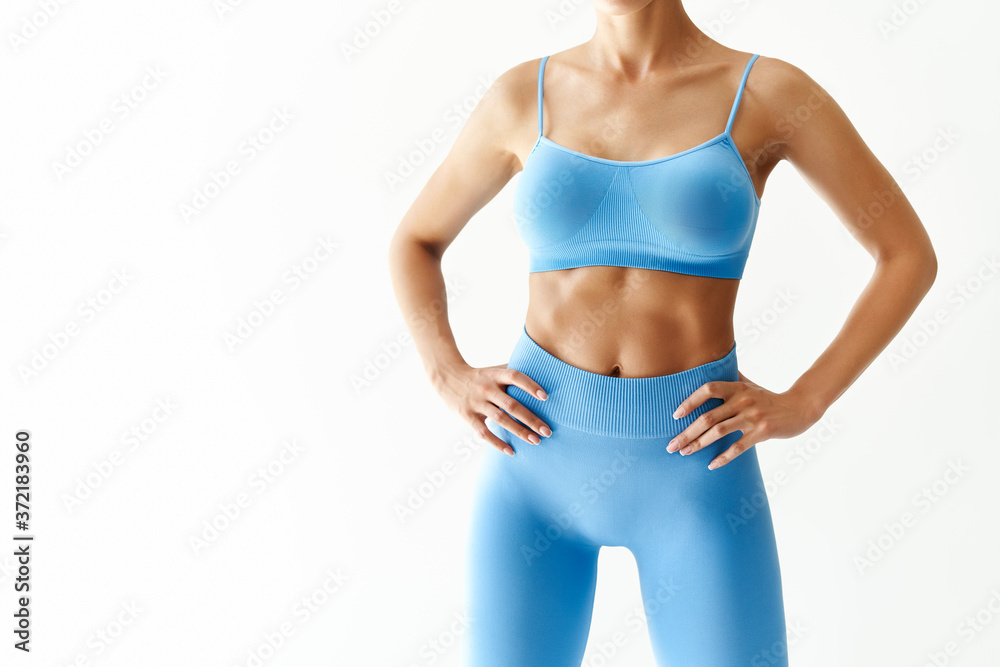 Obraz premium Cropped image of fit woman torso on white background with copy space