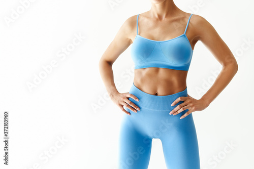 Cropped image of fit woman torso  on white background with copy space