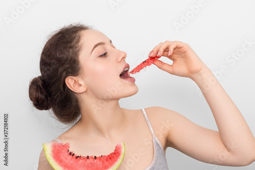 Girl with a slice of watermelon on a gray background.