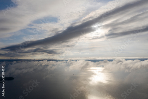 Aerial view clouds over the sea. View seashore and coastline from drone. Aerial top view cloudscape. Texture of clouds. View from above. Sunrise or sunset over clouds. Aerial ocean background