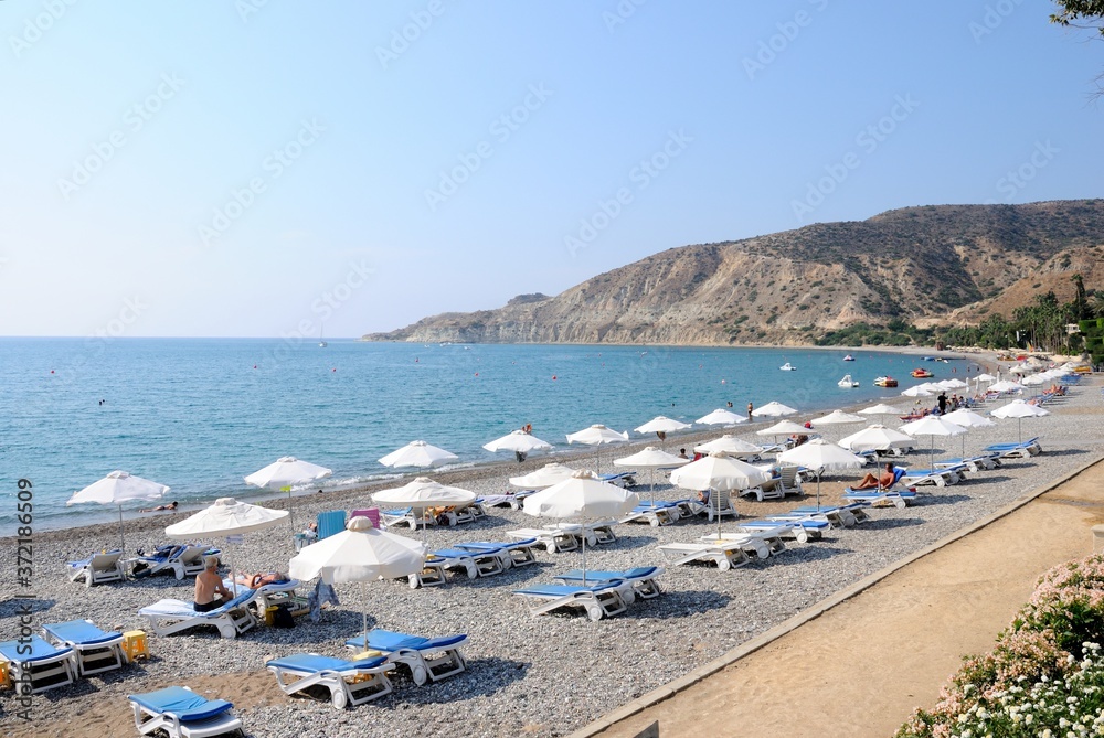View of Pissouri (Pitch-dark night) beach with sun loungers and umbrellas in South Cyprus