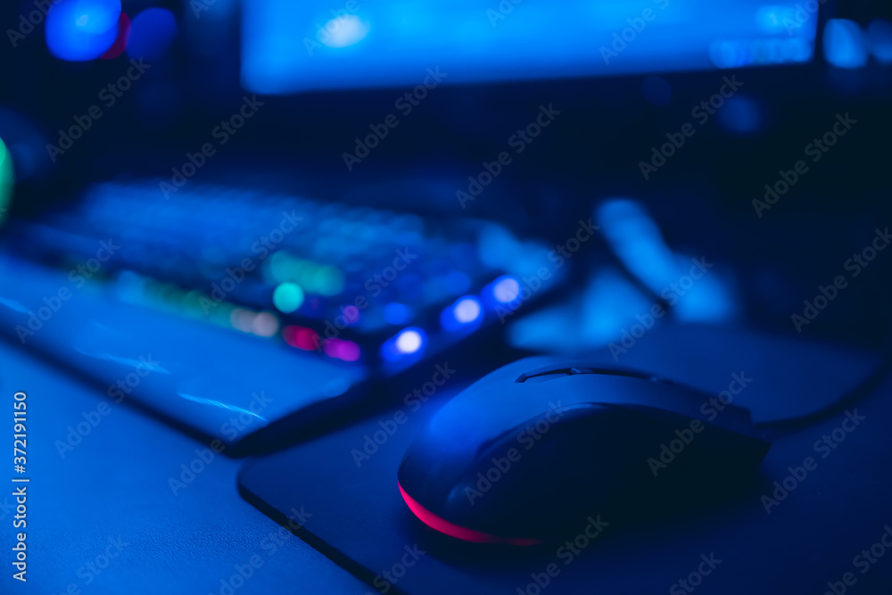 Professional cyber video gamer studio room with personal computer armchair, keyboard for stream in neon color blur background. Soft focus Professional cyber video gamer studio room with personal computer armchair, keyboard for stream in neon color blur background. Soft focus