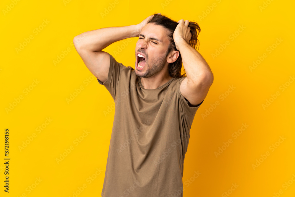 Young handsome man isolated on yellow background stressed overwhelmed Young handsome man isolated on yellow background stressed overwhelmed