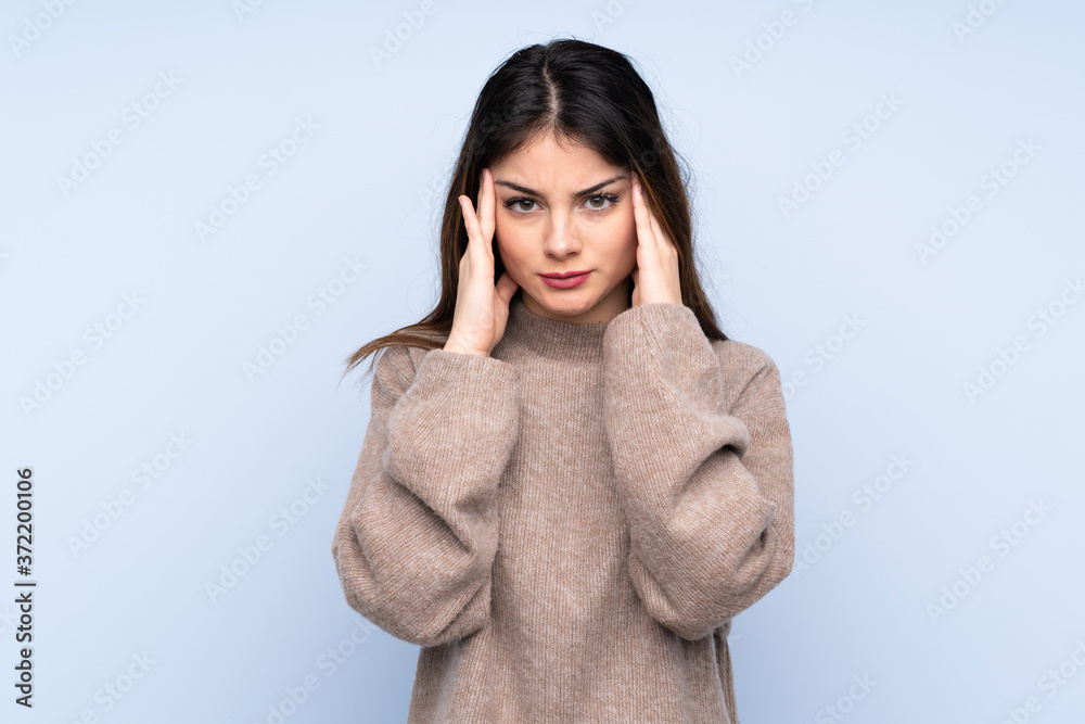 Young brunette woman wearing a sweater over isolated blue background with headache Young brunette woman wearing a sweater over isolated blue background with headache