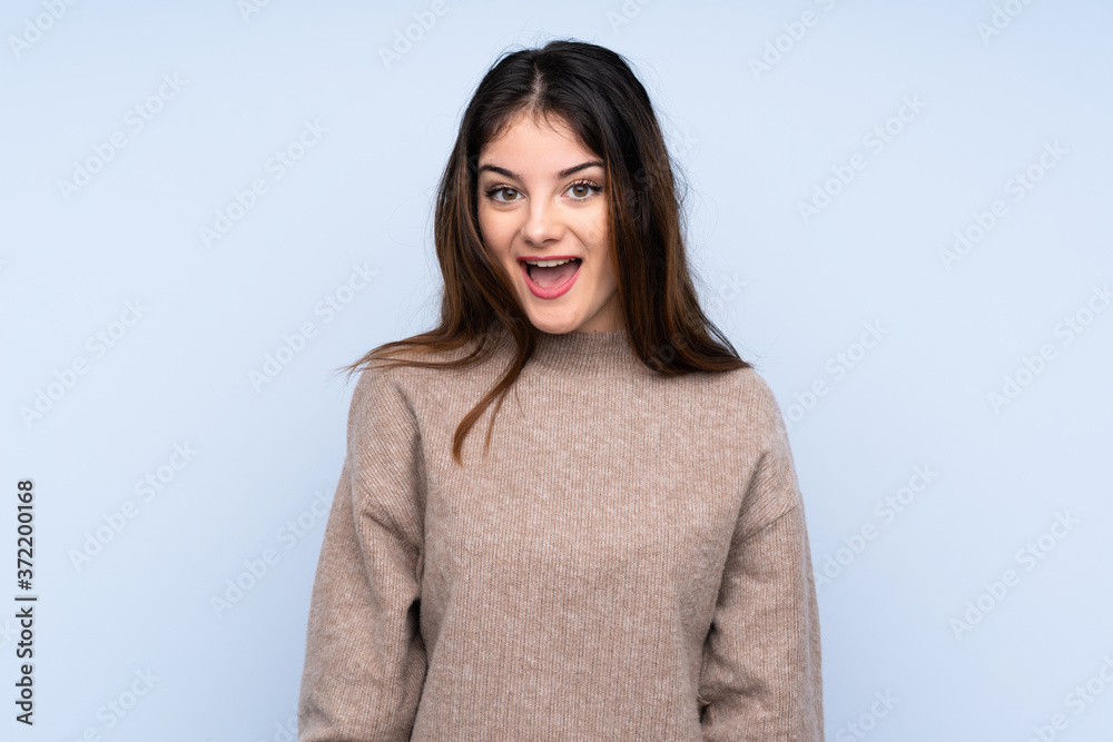Young brunette woman wearing a sweater over isolated blue background with surprise facial expression Young brunette woman wearing a sweater over isolated blue background with surprise facial expression