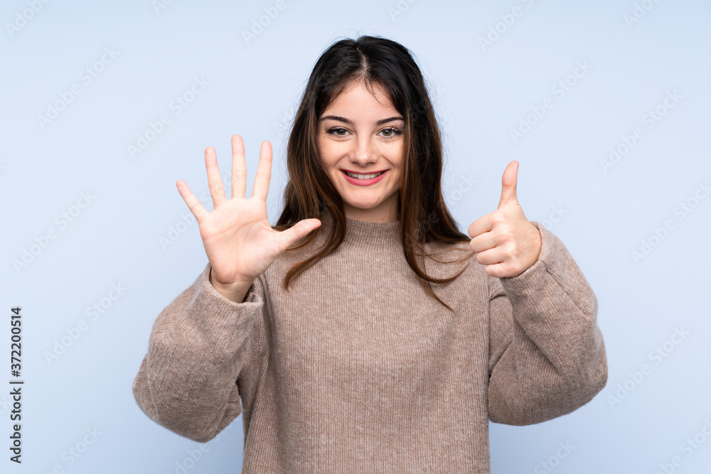 Young brunette woman wearing a sweater over isolated blue background counting six with fingers Young brunette woman wearing a sweater over isolated blue background counting six with fingers