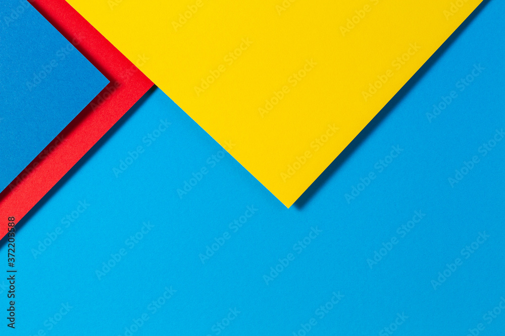 Abstract color papers geometry flat lay composition background with blue, yellow and red color tones Abstract color papers geometry flat lay composition background with blue, yellow and red color tones