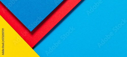 Abstract color papers geometry flat lay composition background with blue, yellow and red color tones