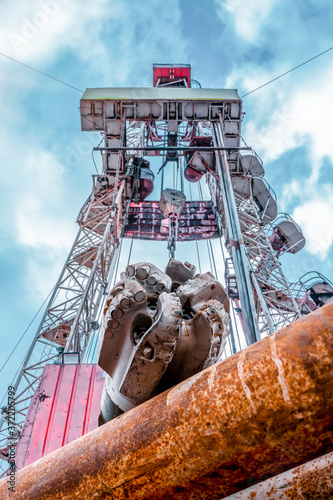 Oil and Gas Drilling Rig onshore dessert with dramatic cloudscape. Oil drilling rig operation on the oil platform in oil and gas industry. photo