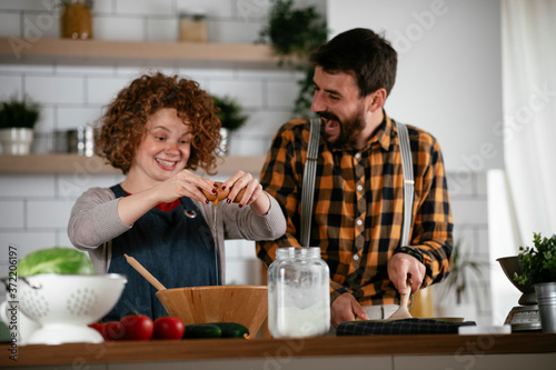 Young couple making delicious food at home. Loving couple enjoying in the kitchen..