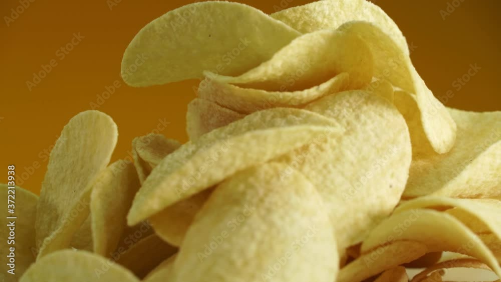 Potato chips rotate in front of the camera. Potato chips rotate in front of the camera.