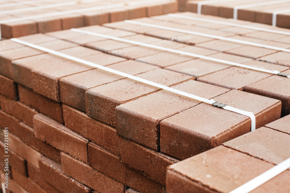pallets and packages of freshly produced red bricks in a construction warehouse on the street. Concept of repair and building materials pallets and packages of freshly produced red bricks in a construction warehouse on the street. Concept of repair and building materials