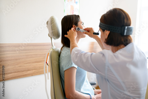 Quadro em tela Female ent doctor and patient in office, ear exam