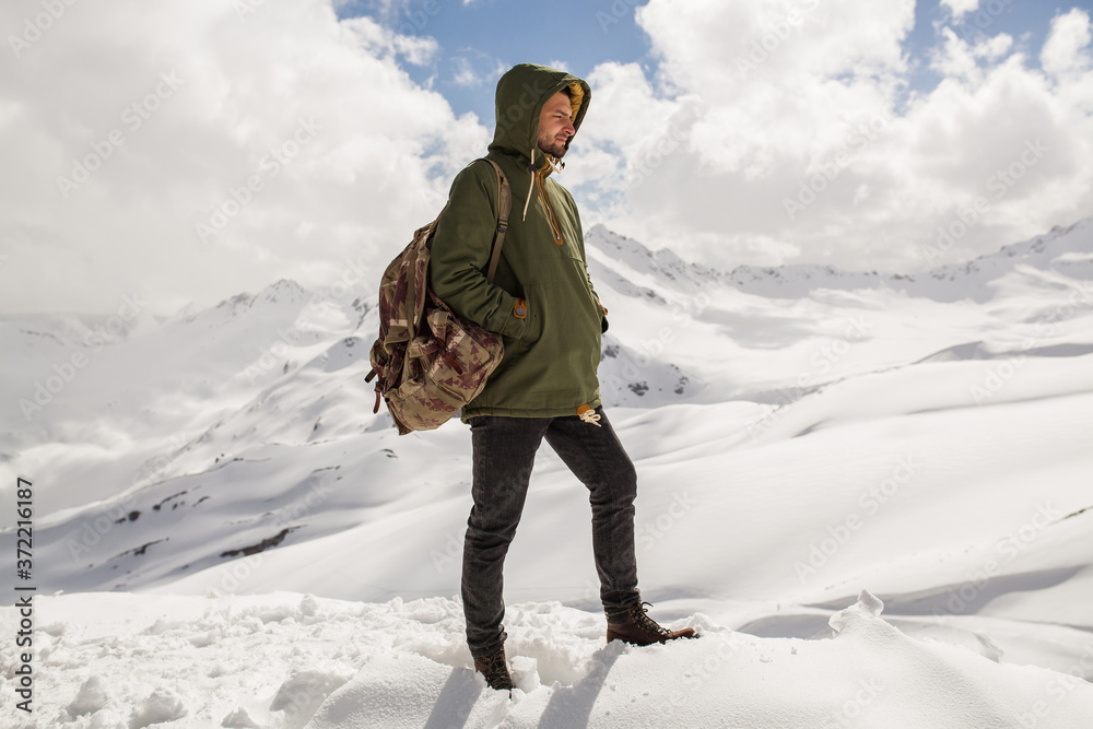 young hipster man hiking in mountains winter vacation traveling north snow warm clothes backpack anorak Stock Photo Adobe Stock