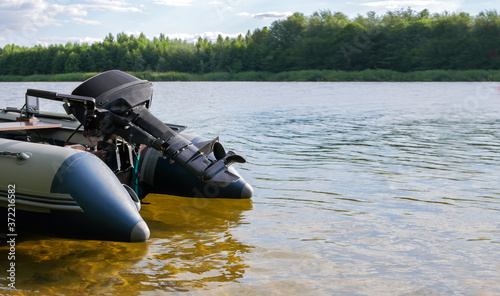 Pvc inflatable boat with a motor on the water near the shore. Copy space