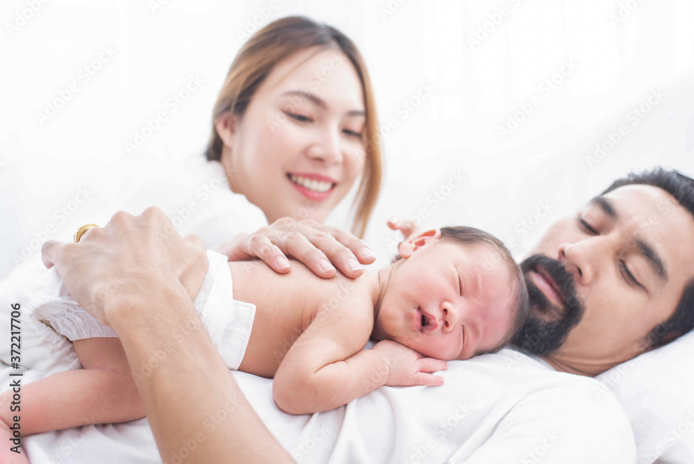 smiling mother and father holding their newborn baby at home..portrait of happy family at home, young parents holding on hands little sweet newborn baby, love and happiness concept. smiling mother and father holding their newborn baby at home..portrait of happy family at home, young parents holding on hands little sweet newborn baby, love and happiness concept.