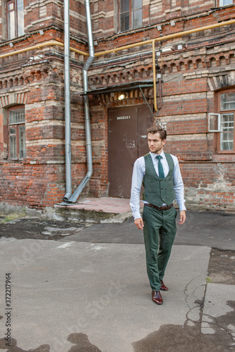 a man stands near a brick house