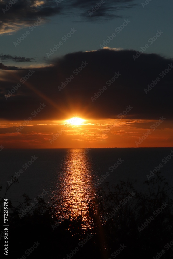 Hunstanton beach sun set over the sea ,glowing deep orange ball of fire 