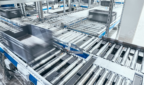 Modern conveyor system with boxes in motion, shallow depth of field. photo