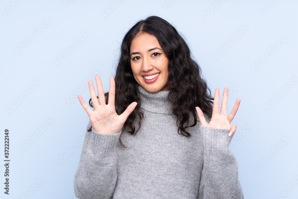 Spanish Chinese woman over isolated blue background counting nine with fingers Spanish Chinese woman over isolated blue background counting nine with fingers