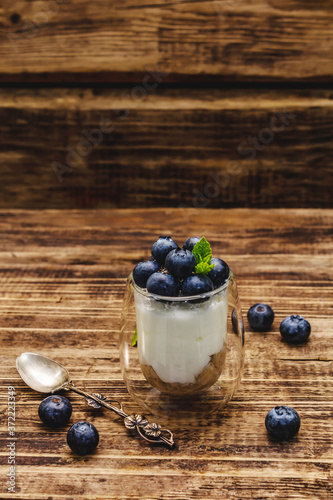 Yogurt with blueberries and chia seeds on wooden cutting board