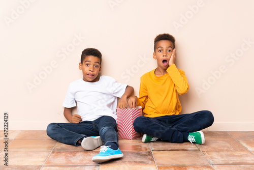 African American brothers holding popcorns and doing surprise gesture