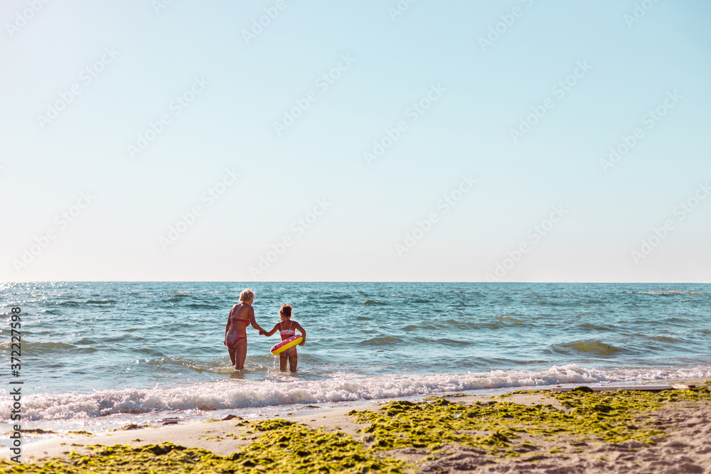 Mother and her little daughter having fun at sea. Travel and vacation concept