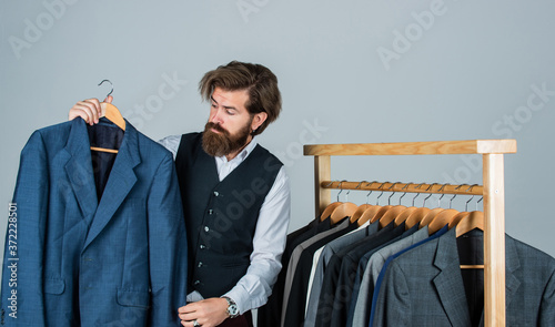 Bearded man collector vintage clothes showing formal suit, second hand store concept photo