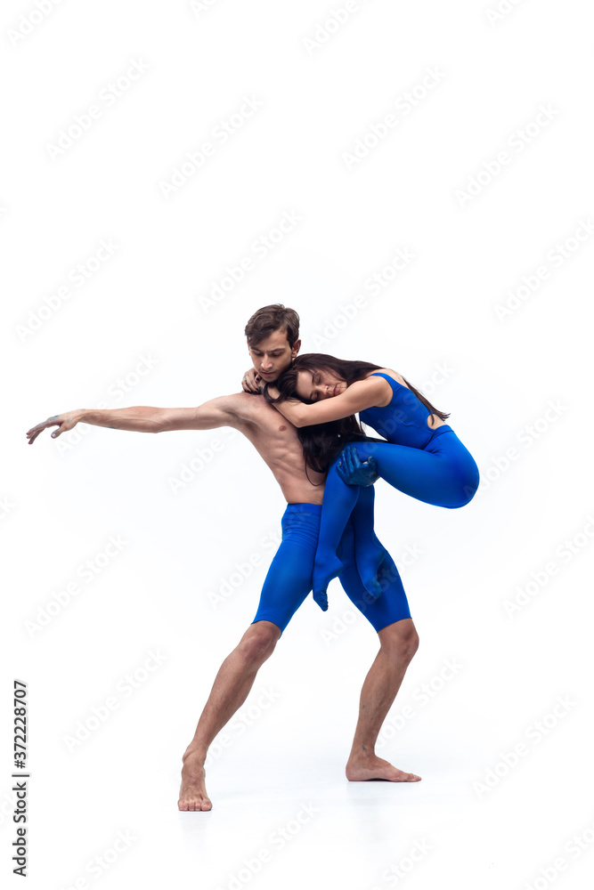 Hug. Couple of modern dancers, art contemp dance, blue and white combination of emotions. Flexibility and grace in motion and action on white studio background. Fashion and beauty, artwork concept.