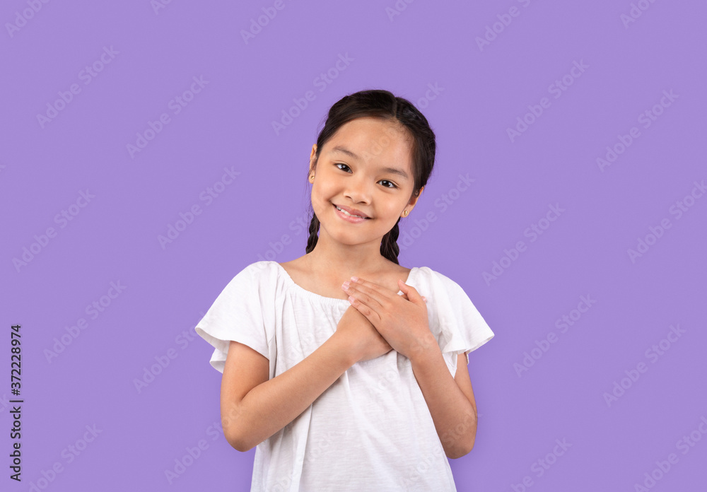 Thankful Chinese Girl Pressing Hands To Chest Over Purple Background Thankful Chinese Girl Pressing Hands To Chest Over Purple Background