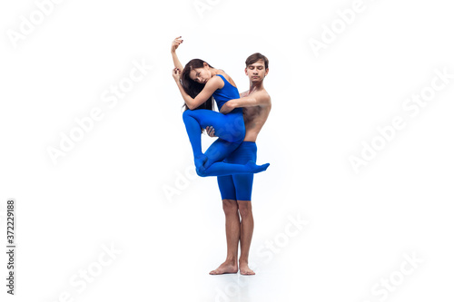 Winter. Couple of modern dancers, art contemp dance, blue and white combination of emotions. Flexibility and grace in motion and action on white studio background. Fashion and beauty, artwork concept.