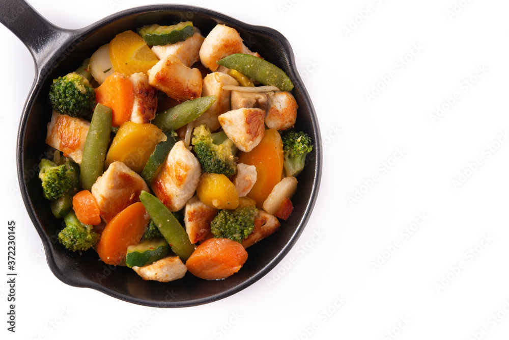 Stir fry chicken with vegetables on iron pan isolated on white background. Top view. Copy space Stir fry chicken with vegetables on iron pan isolated on white background. Top view. Copy space
