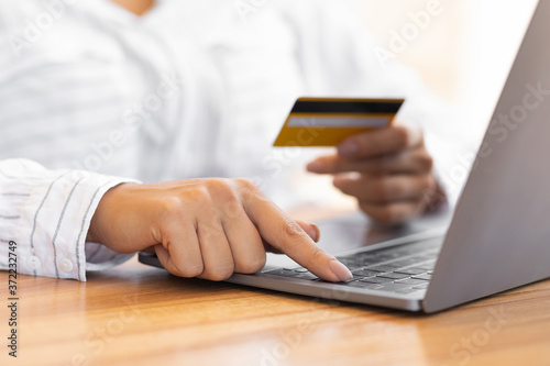 Woman using pc and credit card at home