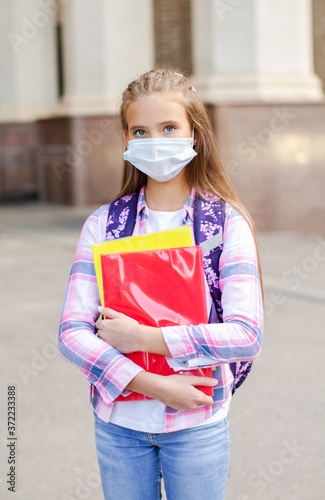 Little girl child with face mask and backpack. Education concept. Back to school after covid-19. © svetamart