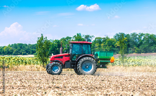 The tractor applies fertilizer to the soil