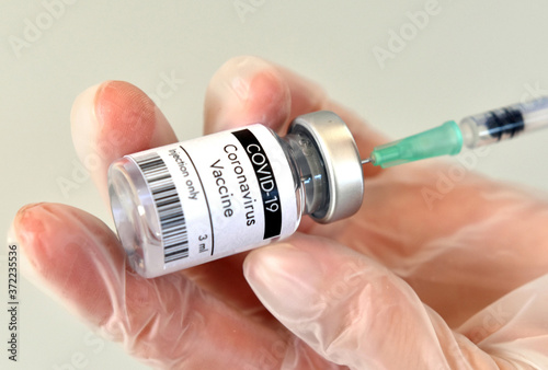 COVID-19 vaccine vial, bottle in hand.at Pfizer laboratory photo