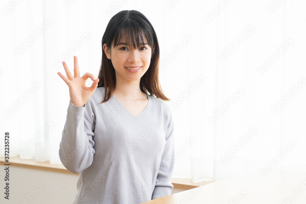 OKのポーズをする若い女性 OKのポーズをする若い女性