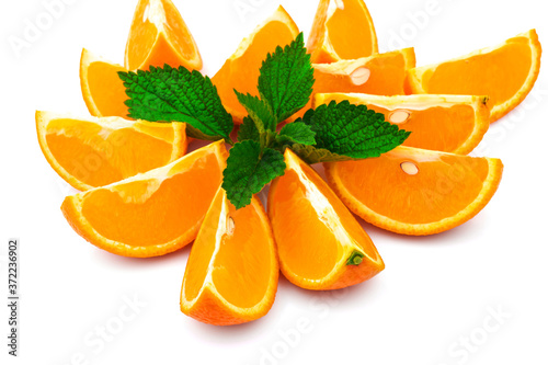 Macro view of orange with slices and green leaf of mint on white background