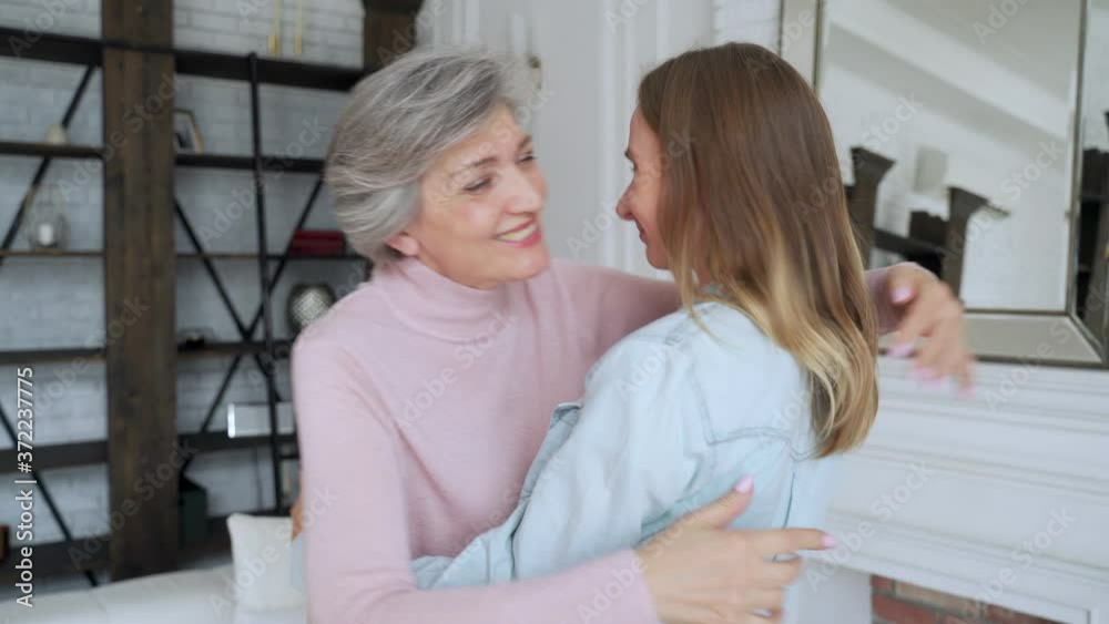 Old mother and mature daughter hugging at home. Happy senior mother and adult daughter embracing with love Old mother and mature daughter hugging at home. Happy senior mother and adult daughter embracing with love